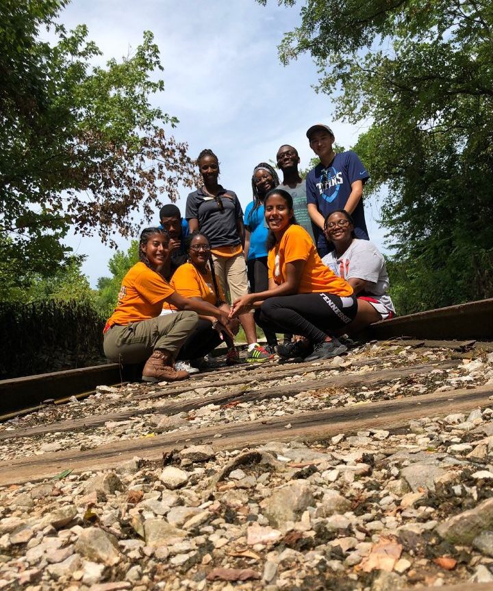 Group of students pose on railroad tracks